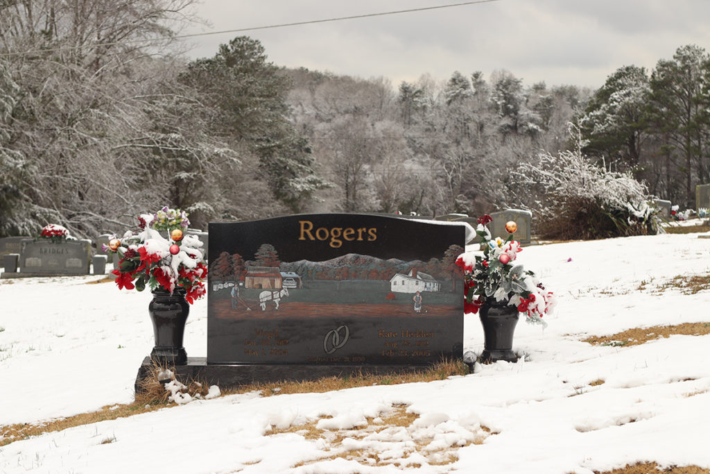 Grave Marker depicting a snowy scene in a cemetery.